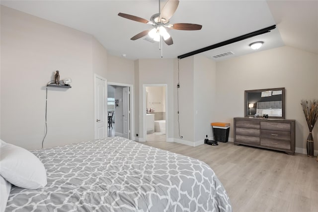 bedroom with vaulted ceiling, ensuite bathroom, light wood-type flooring, and ceiling fan