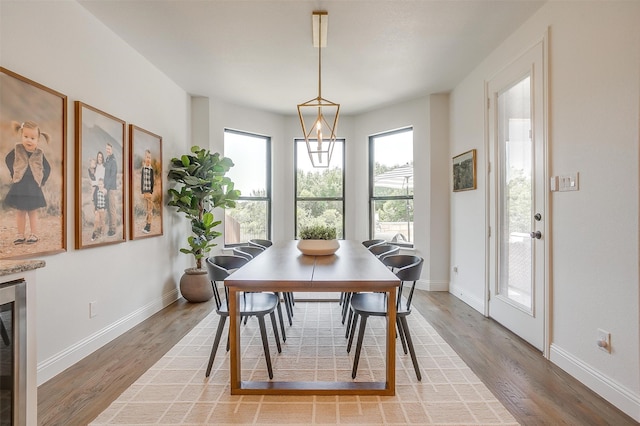 dining area featuring wood-type flooring and beverage cooler