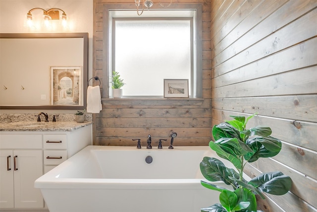 bathroom featuring vanity, a bathtub, and wooden walls