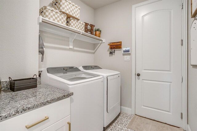 laundry area featuring independent washer and dryer and cabinets