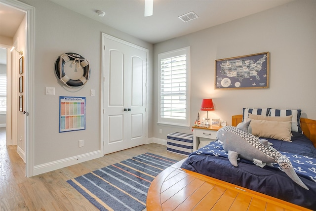 bedroom with a closet, hardwood / wood-style flooring, and ceiling fan