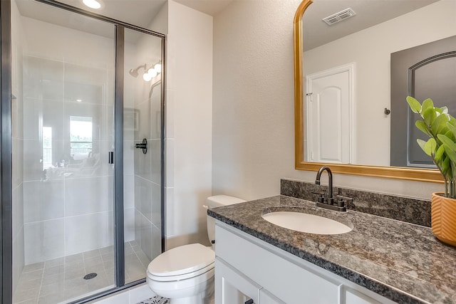 bathroom featuring vanity, toilet, and a shower with shower door