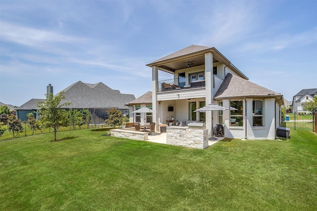 rear view of house featuring a balcony, a patio, a lawn, and an outdoor bar