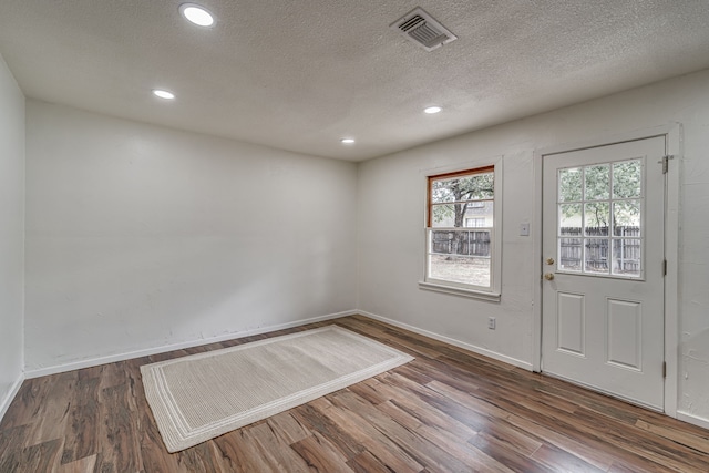 entrance foyer with dark wood-type flooring and a textured ceiling