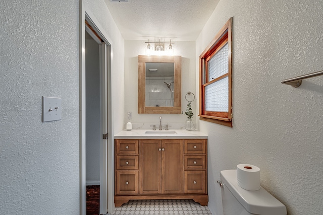 bathroom with a shower, vanity, toilet, and a textured ceiling