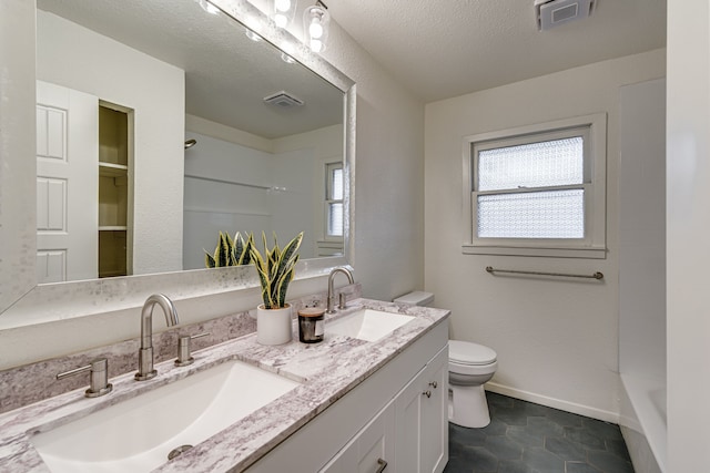 bathroom with tile patterned floors, vanity, toilet, and a textured ceiling