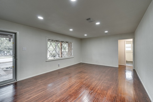 spare room with plenty of natural light and dark wood-type flooring