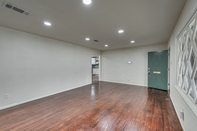 spare room featuring dark wood-type flooring