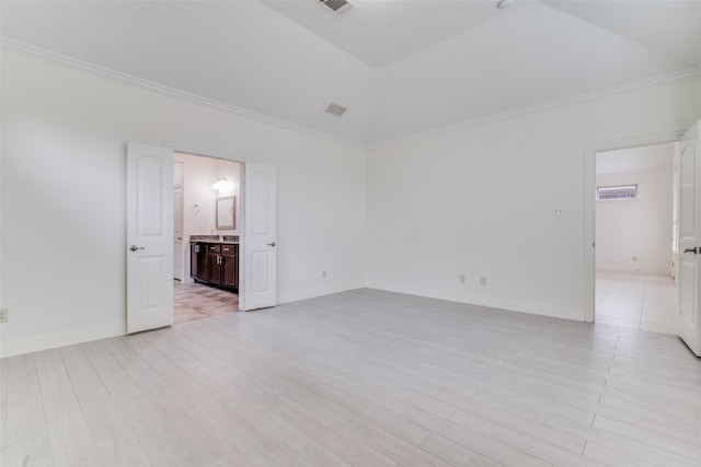 spare room with ornamental molding, vaulted ceiling, and light hardwood / wood-style floors