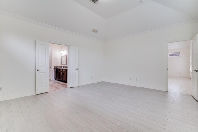 spare room featuring crown molding, light wood finished floors, and baseboards