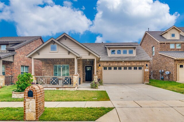 craftsman-style house featuring covered porch, brick siding, driveway, a front lawn, and roof with shingles