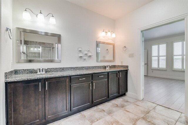 full bathroom featuring double vanity, a shower with shower door, baseboards, and tile patterned flooring