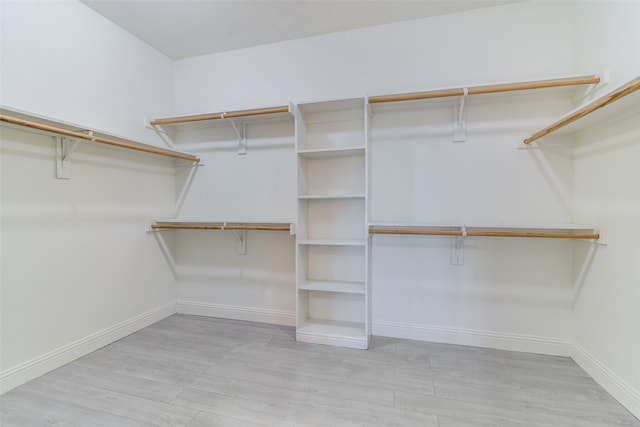 walk in closet with light hardwood / wood-style flooring