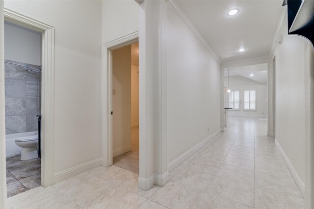 hallway with crown molding, light tile patterned flooring, recessed lighting, and baseboards