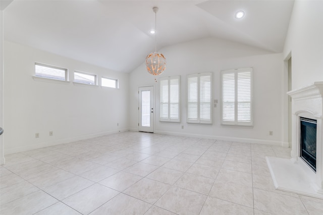 unfurnished living room featuring an inviting chandelier, high vaulted ceiling, and light tile patterned floors