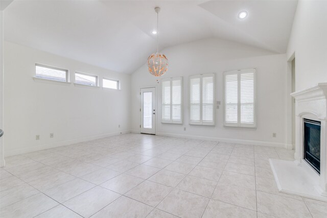 unfurnished living room with vaulted ceiling, light tile patterned floors, a chandelier, a fireplace with raised hearth, and baseboards