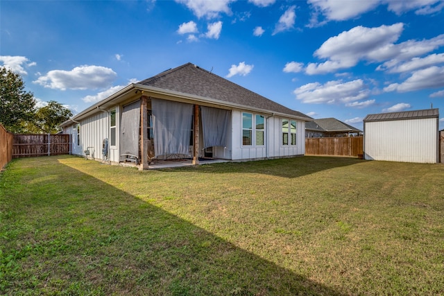 back of house with a yard and a storage shed