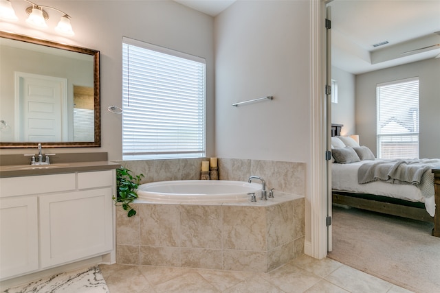 bathroom featuring vanity, tile patterned flooring, a relaxing tiled tub, and plenty of natural light