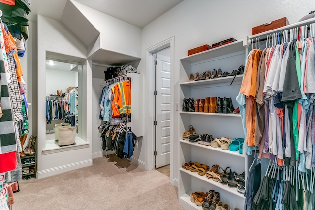 walk in closet featuring light colored carpet