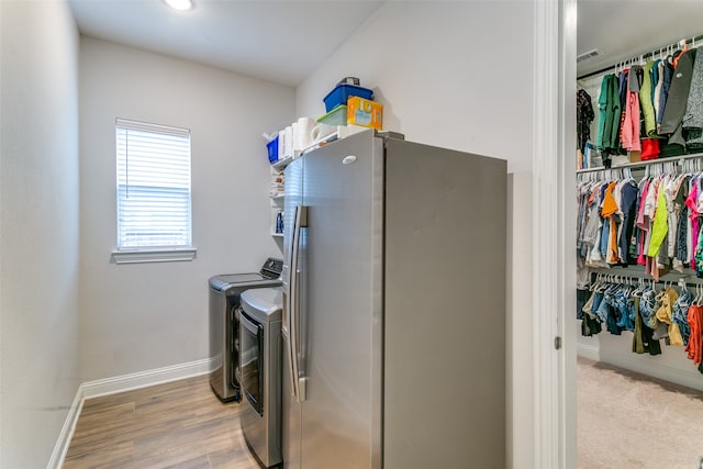 laundry area featuring light hardwood / wood-style floors and washing machine and dryer