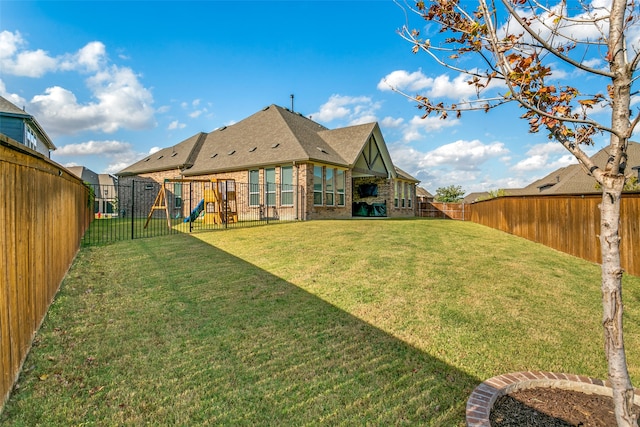 back of house featuring a playground and a lawn