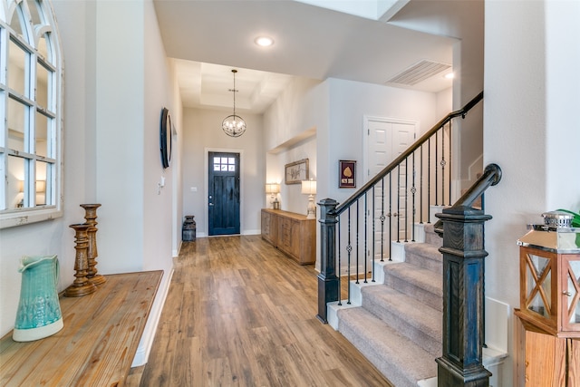 foyer entrance with a notable chandelier and light wood-type flooring