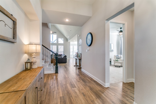 hallway with wood-type flooring and vaulted ceiling