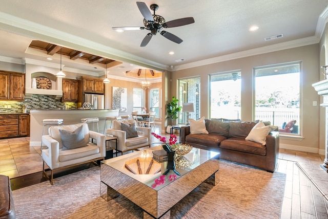 living room featuring beam ceiling, ornamental molding, light hardwood / wood-style floors, and ceiling fan with notable chandelier