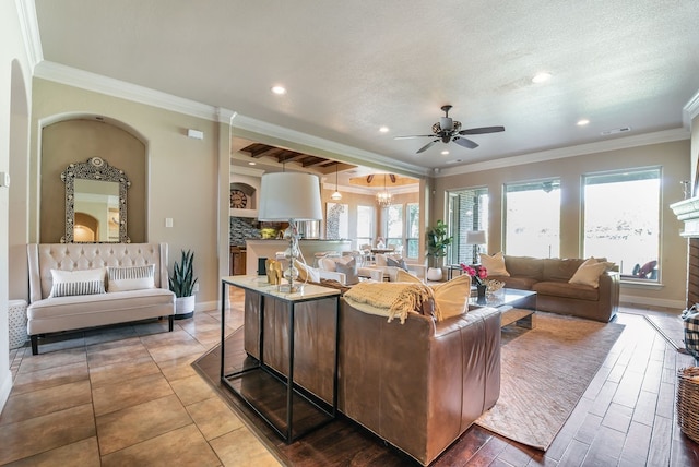 living room with crown molding, ceiling fan, and plenty of natural light