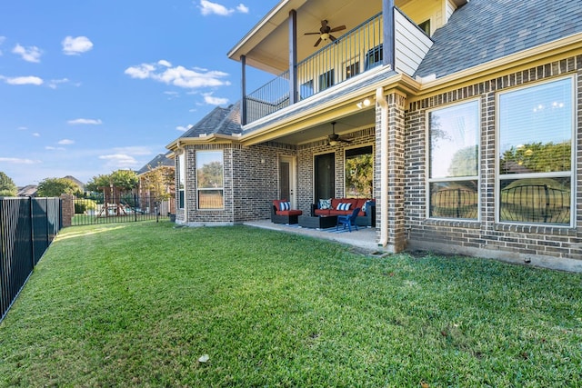 view of yard featuring a patio, ceiling fan, a balcony, and an outdoor hangout area