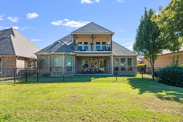 back of property with a patio, ceiling fan, a lawn, and a balcony