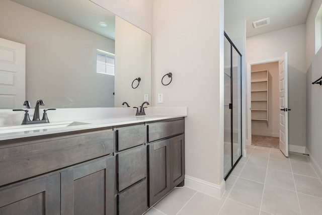 bathroom with vanity, tile patterned flooring, and a shower with door