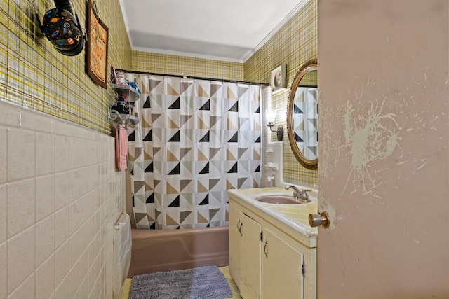 bathroom featuring vanity, crown molding, shower / bathtub combination with curtain, and tile walls