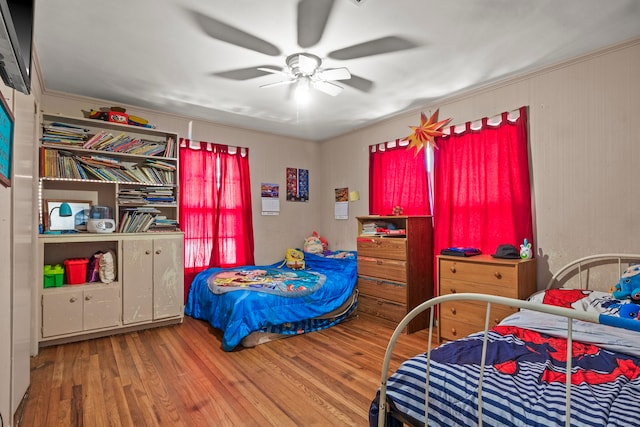 bedroom featuring ornamental molding, hardwood / wood-style floors, and ceiling fan