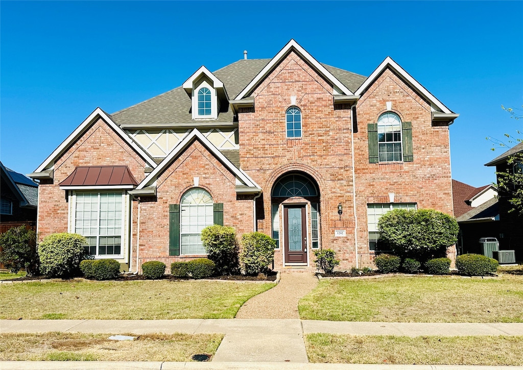 view of front of home with a front lawn and central AC unit