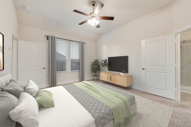 carpeted bedroom with ensuite bath, vaulted ceiling, and ceiling fan