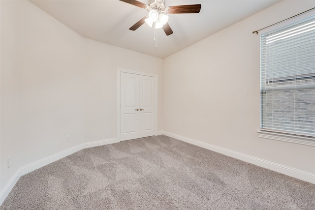 carpeted spare room featuring ceiling fan