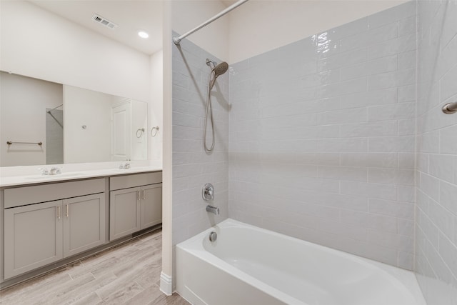 bathroom with vanity, hardwood / wood-style flooring, and tiled shower / bath combo