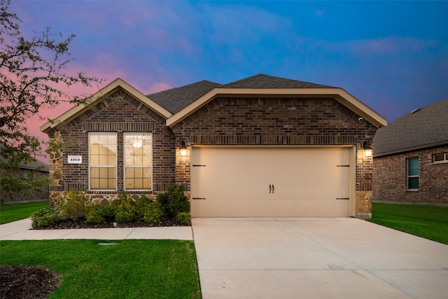 view of front of property featuring a yard and a garage