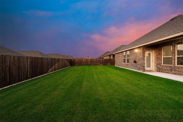 yard at dusk with a patio area