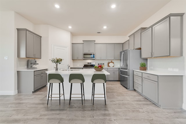 kitchen featuring gray cabinets, light hardwood / wood-style flooring, and stainless steel appliances