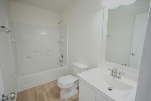 bathroom featuring toilet, vanity, bathtub / shower combination, and wood finished floors