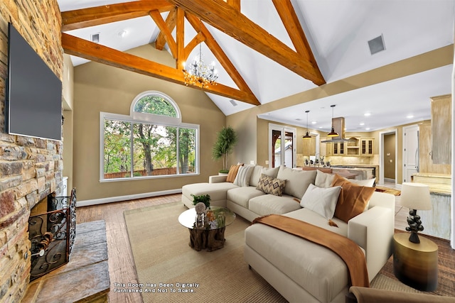 living room with beam ceiling, high vaulted ceiling, light hardwood / wood-style flooring, a stone fireplace, and a notable chandelier