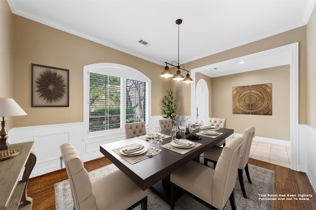 dining room with ornamental molding and dark hardwood / wood-style flooring