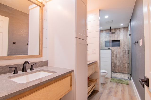 bathroom with vanity, toilet, walk in shower, and hardwood / wood-style floors