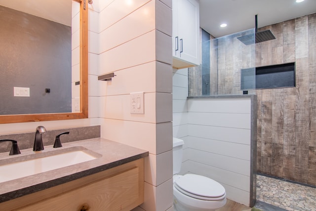 bathroom with vanity, toilet, and tiled shower