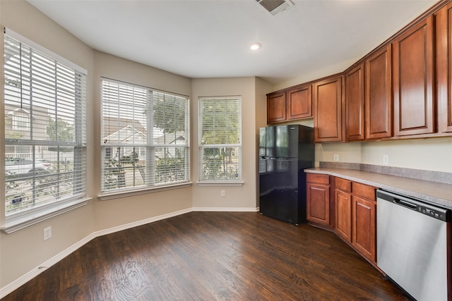 kitchen with dark wood-type flooring, stainless steel dishwasher, and black fridge