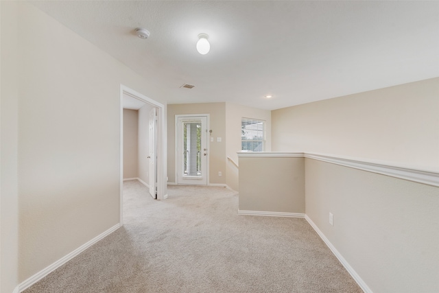 hall featuring light colored carpet