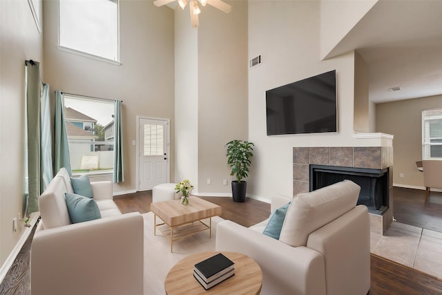 living room with dark wood-style floors, baseboards, and a tiled fireplace