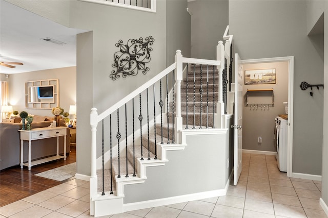 staircase featuring ceiling fan, hardwood / wood-style flooring, and washing machine and dryer